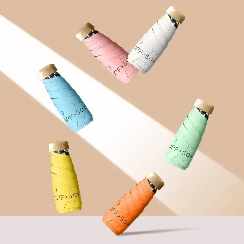 Colorful UV protection women’s umbrella bottles with UPF > 50 labels in sunlight, showcasing sun safety products.