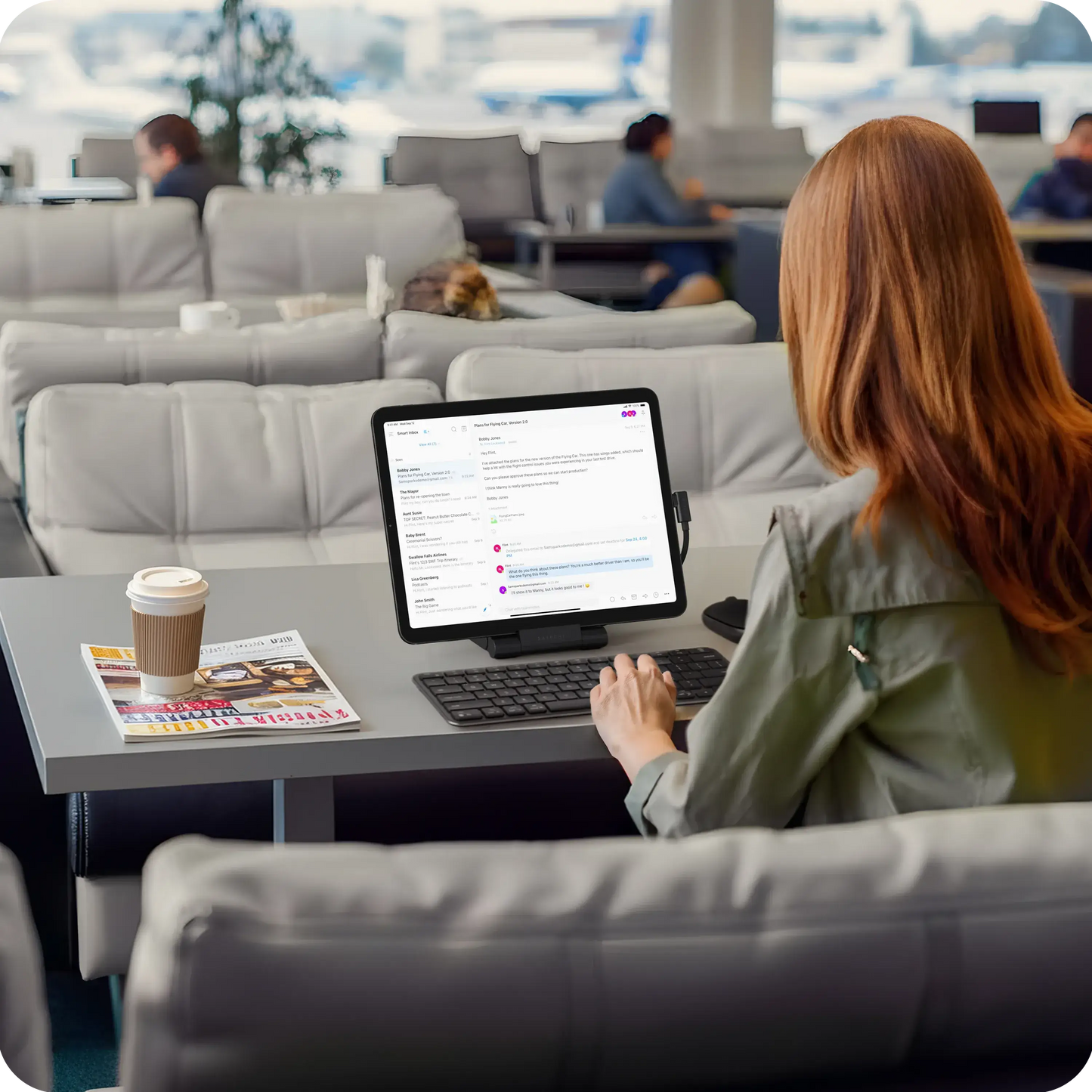 Person using Satechi OntheGo Foldable Stand Hub with iPad in a modern lounge setting.